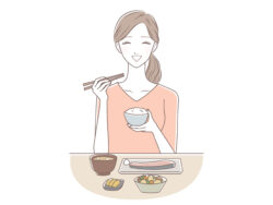 素敵な女性がにっこりとした笑顔で美味しそうなご飯を食べている画像